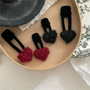 Gros plan de barrettes à cheveux en peluche en forme de cœur rouge et noir avec texture