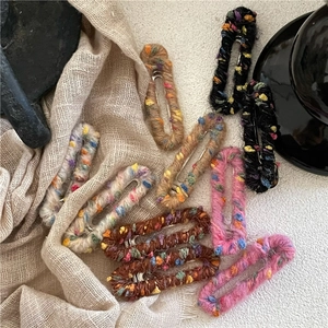 Détail de barrettes à cheveux enveloppées de laine colorée sur un tissu d'automne
