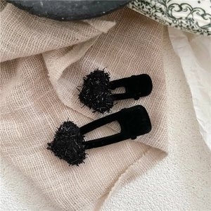 Détails de jolies barrettes en velours noir avec décors en forme de cœur en perles brillantes