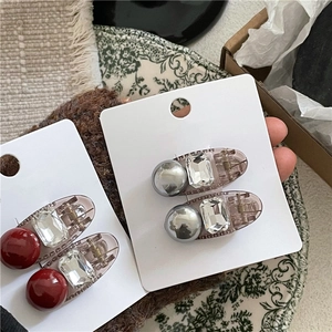 Barrettes élégantes avec perles et strass présentées sur un support en carton chic