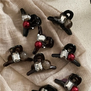 Mini resin hair clips with rectangular rhinestones and round pearls on linen background