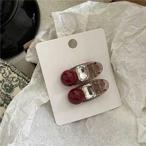 Détail de pinces à cheveux rétro avec perles rouge foncé et strass carrés scintillants