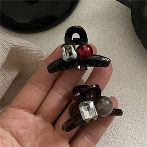 Mini hair claw clips set in black and amber resin with rhinestone and pearl detail