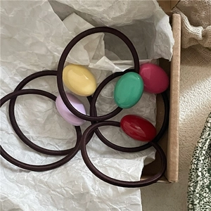 Detail of colorful oval resin beads on high-elastic black hair ties in a gift box