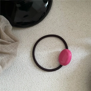 Detail of a rose pink oval resin bead on a high-elasticity black hair tie for women