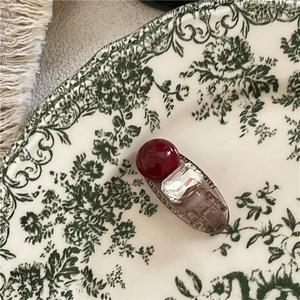 Vue macro d'une barrette avec perle bordeaux et cristal sur un plateau en céramique