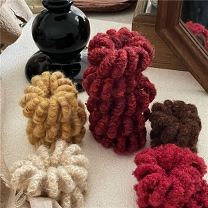 Gros plan sur des chouchous spirales en laine aux couleurs hivernales foncées