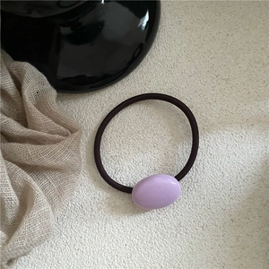 Close-up of a dark coffee hair tie featuring a purple oval resin pebble and high elasticity