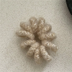Vue détaillée d'un chouchou en fausse fourrure beige avec élastique haute résistance