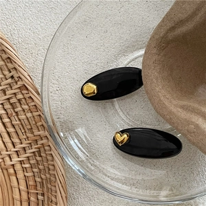 Barrettes à cheveux noires ovales élégantes avec cœur doré et accents géométriques