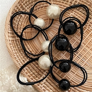 Elegant black elastic hair bands featuring large black and white pearl bead accents