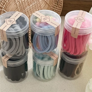 Élastiques à cheveux crème dans des pots transparents avec plusieurs ensembles de couleurs