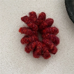 Détail d'un élastique spirale rouge foncé avec texture tricotée pour queue de cheval