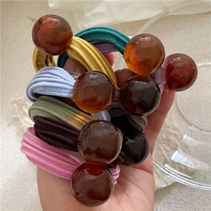Detail of colorful elastic hair ties with amber transparent round beads decoration