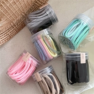 Gros plan d'élastiques à cheveux pastel en bocaux transparents avec sceau de marque