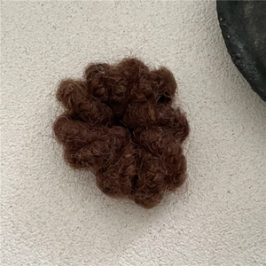 Vue détaillée de l'élastique à cheveux en mohair marron foncé avec texture laineuse