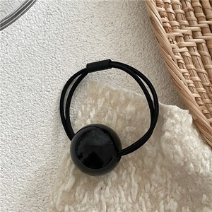 Detail of double-strand elastic hair tie with a glossy black polished decorative bead