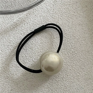 Close-up of a high-elastic black hair tie featuring a large glossy white imitation pearl