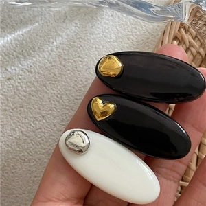 Détails des accents métalliques en forme de cœur sur barrettes noires et blanches