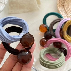 Detail of high-elasticity cream hair ties with amber resin beads in Morandi colors