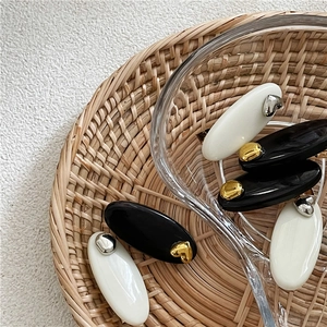 Set de barrettes ovales élégantes noires et blanches avec détails de cœurs dorés en acrylique