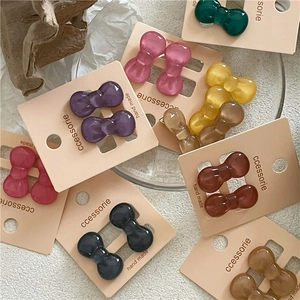 Mini colorful glossy plastic bow hair clips for girls displayed on card packaging