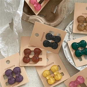 Close-up of colorful resin bow hair clips organized on handmade display cards