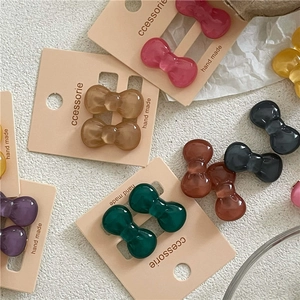 Macro shot of colorful resin bow hair clips in various shades on textured display cards