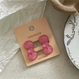 Pair of cute pink translucent resin bow hair clips on a craft display card
