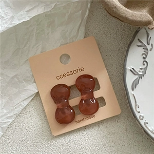Macro shot of brown resin bow hair clips on handmade card with high gloss finish