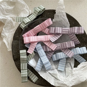 Pink and pastel gingham plaid bow hair clips set for girls on a decorative stone tray