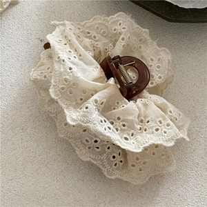 Detailansicht der eleganten beige Spitzenstickerei und der Muschel-Haarklammer-Struktur