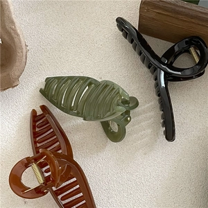 Close-up of three jelly textured cross hair claws in black, olive green, and amber colors