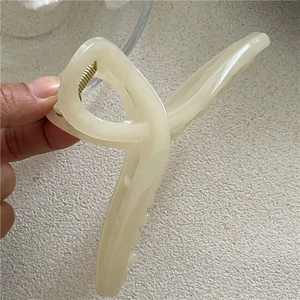 Close-up of a large cream hair claw clip with strong gold spring for thick hair