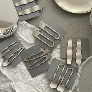 Lot de barrettes à cheveux argentées mates, formes ondulées et géométriques sur carte