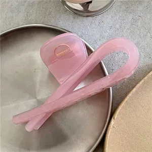 Pince à cheveux géométrique rose sur plateau en métal argenté avec ressort doré