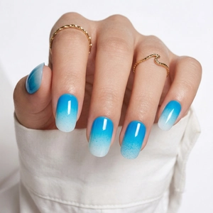 Macro shot of long oval blue gradient press-on nails with glossy finish for women