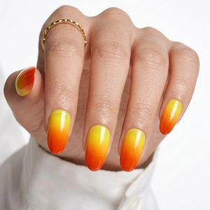 Detailed view of long almond press-on nails with bright yellow to orange sunset gradient