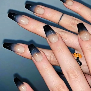 Detailed macro view of long coffin shape press-on nails with black ombre glossy finish