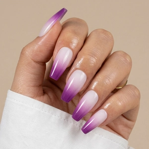 Detail of long coffin press-on nails with purple ombre gradient and high gloss finish