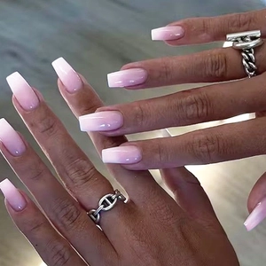 Close-up of long coffin-shaped ombre press-on nails in soft pink and white gradient