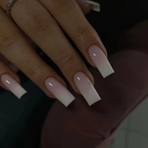 Detail view of long square ombre press-on nails with pink and white gradient finish
