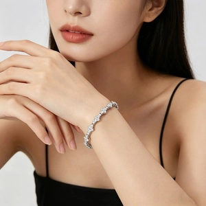Sparkling silver zircon flower chain bracelet worn by a model on black dress background