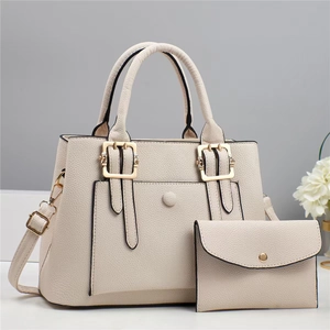 Detail view of cream-white tote bag with envelope pouch and textured leather finish