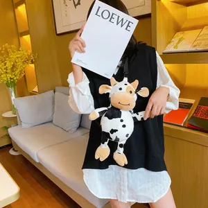 Cute cow plush crossbody bag with black and white spots and a thin shoulder strap