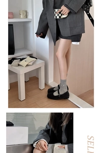 Détail de chaussettes en maille grise avec broderie cœur blanc et revers élégants