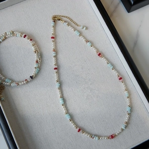 Detail of freshwater pearl and gemstone necklace set with gold extension chain