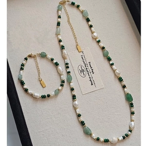 Detail of freshwater pearl and green agate necklace set with gold metallic accents