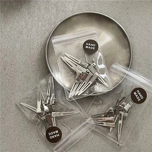 Set of 10 silver metal duckbill hair clips for styling in minimalist handmade packaging
