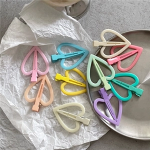 Détail de pinces à cheveux en forme de cœur aux couleurs macaron sur un plateau